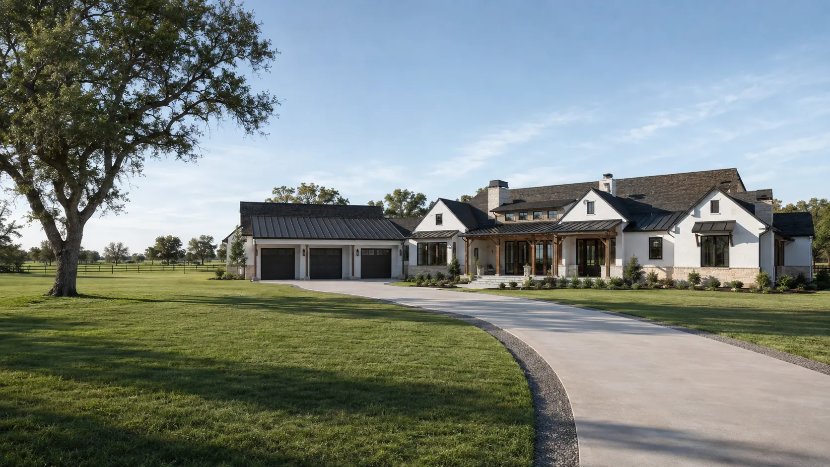 A long single-story white farmhouse with a standing-seam metal roof, timber porch and three-car garage, reached by a curving drive across open pasture near Needville, Texas