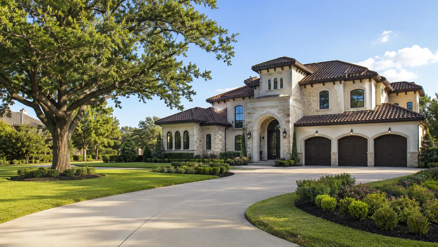A stone and stucco Mediterranean-style custom home with a barrel-tile roof and arched entry, framed by a large mature oak on a wide Pecan Grove lot